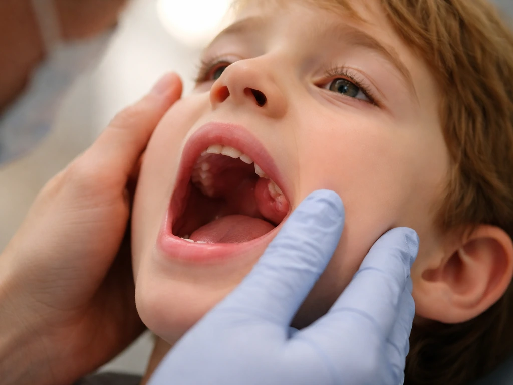 Close-up of a child’s mouth with a single swollen gum area near an upper tooth, suggesting urgent dental concern.